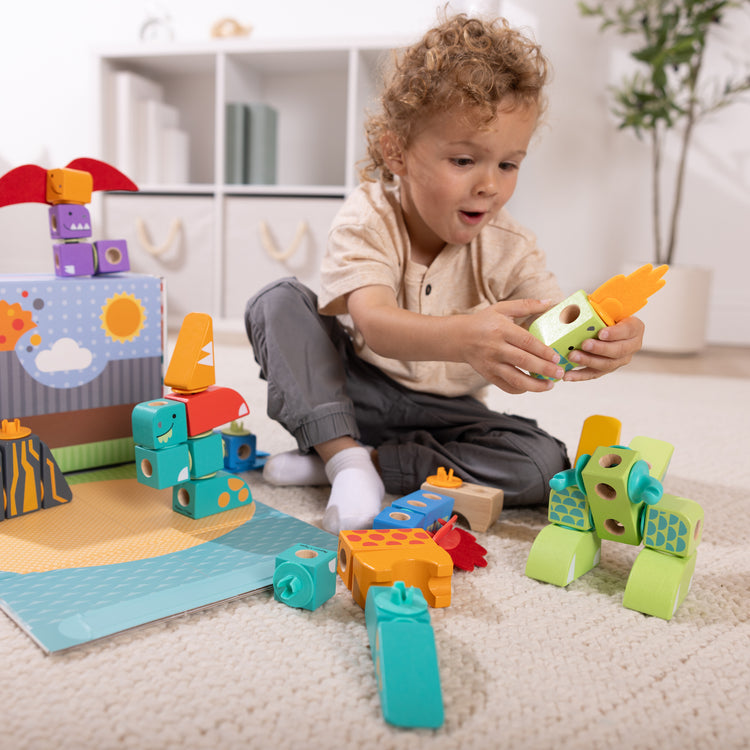 A kid playing with The Melissa & Doug Blockables™ Dinosaur Snap And Play, Mix And Match Connectable Wooden Building Blocks Play Set Toy for Preschool Boys And Girls (69 Pcs)