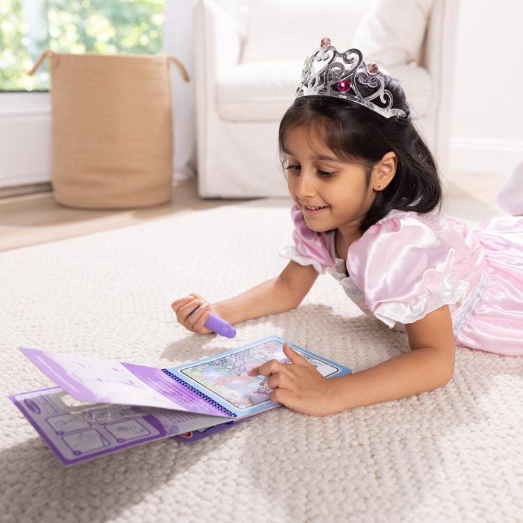 A kid playing with The Melissa & Doug Water WOW! Reusable Water-Reveal Coloring Activity Pad Travel Toy – Unicorn