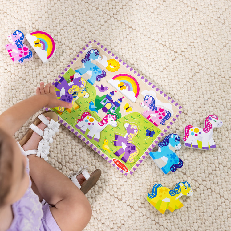 A kid playing with The Melissa & Doug Wooden 6-Piece Unicorn and Rainbow Chunky Puzzle for Toddler Boys and Girls 2+