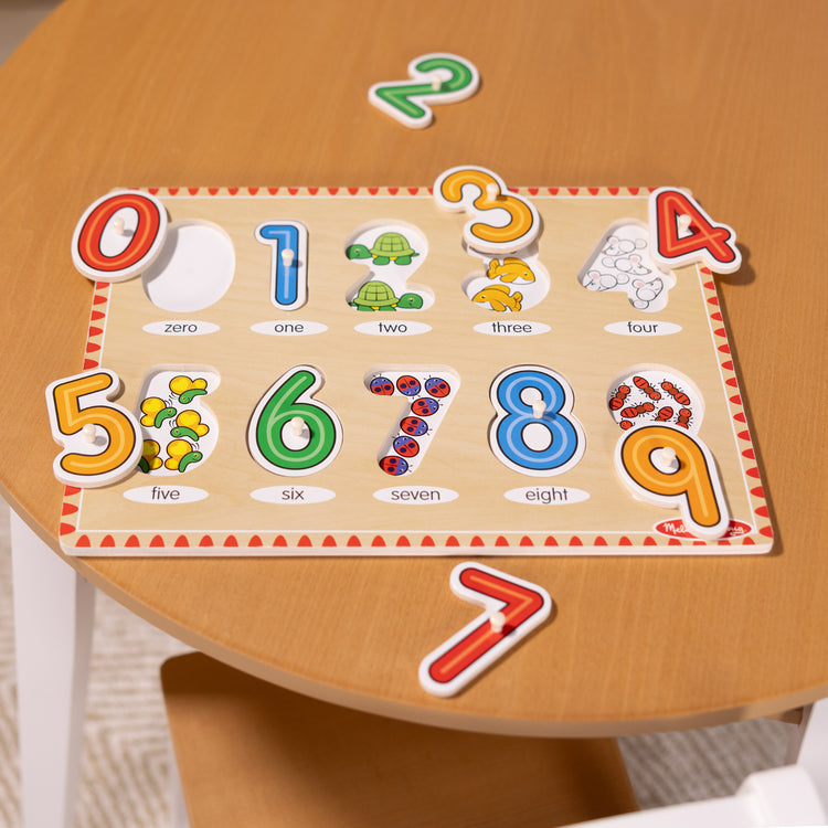 A playroom scene with The Melissa & Doug Lift & See Numbers Wooden Peg Puzzle - 10 Pieces