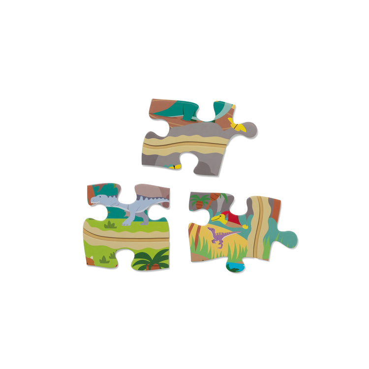 The loose pieces of The Melissa & Doug Dinosaur Adventure Tracks Cardboard Jigsaw Floor Puzzle and 2 Wind-Up Dinos – 48 Pieces, for Boys and Girls 3+ 