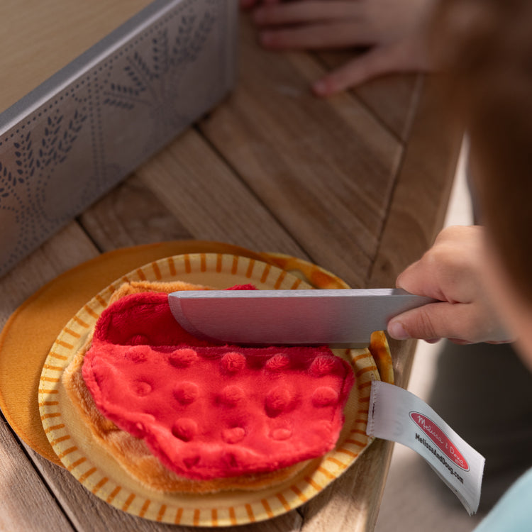 A kid playing with The Melissa & Doug Make and Bake Pies Pretend Play Food Set And Wooden Oven With Squishy Dough for Ages 3+