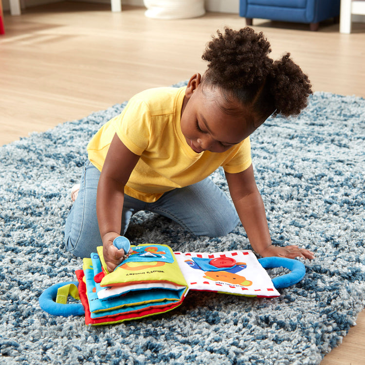 A kid playing with The Melissa & Doug K’s Kids My First Activity Book 8-Page Soft Book for Babies and Toddlers